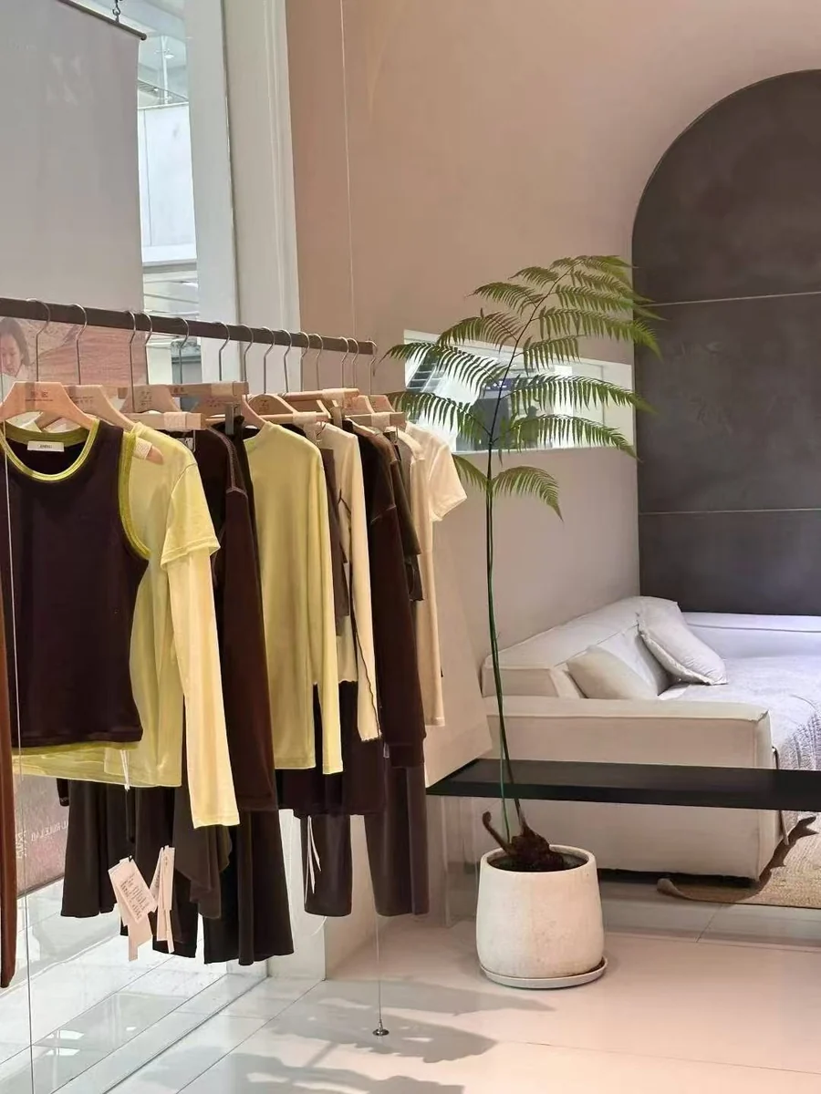 Garment display rail beside seating and a plant in our showroom