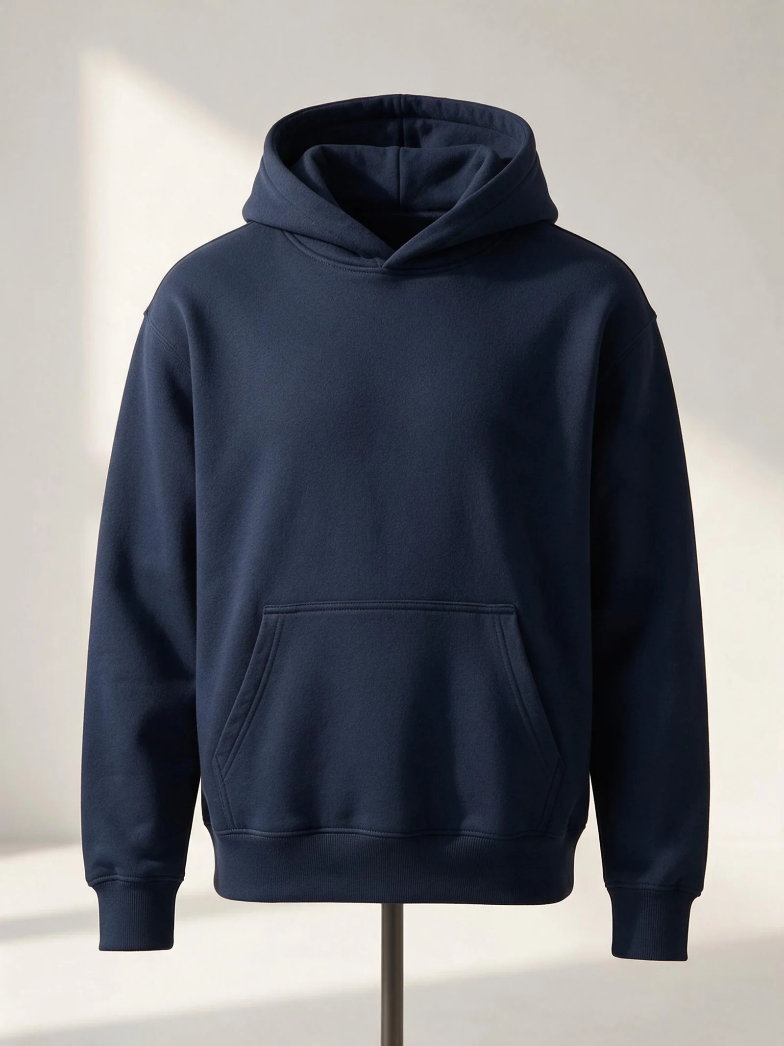 A navy pullover hoodie with ribbed cuffs, a ribbed hem and a kangaroo pocket.