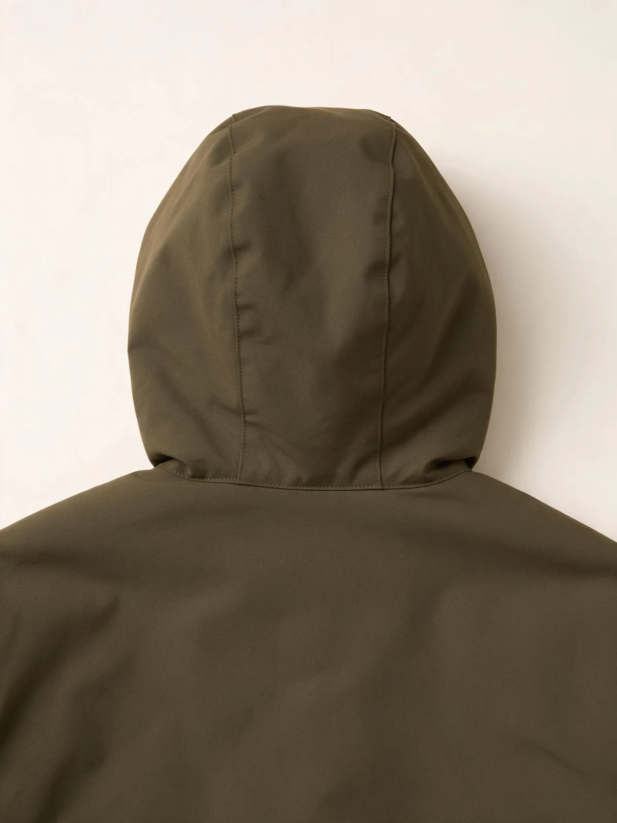 Back of an olive jacket hood showing its center panel and neckline connection.