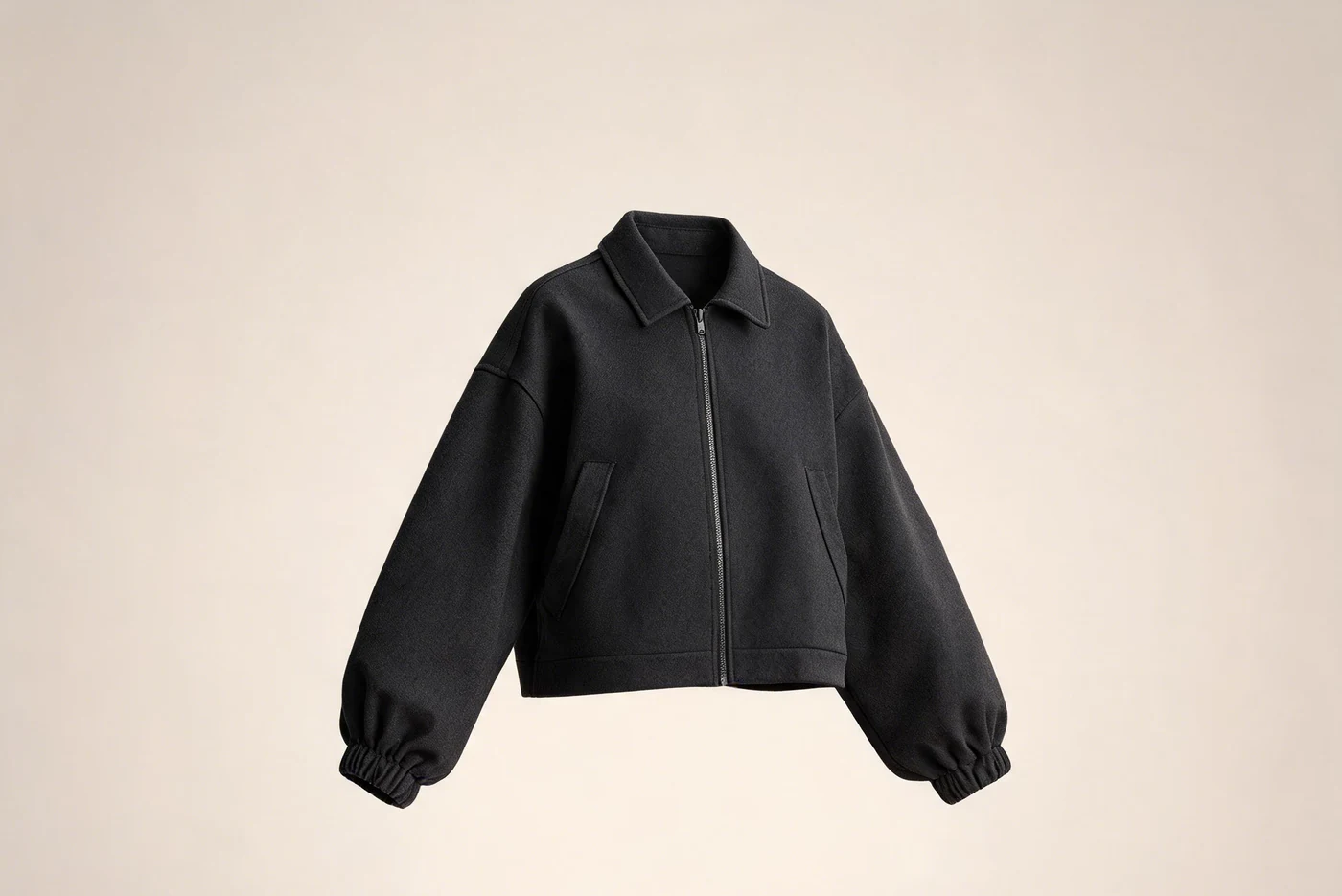 Black boxy zip jacket with a point collar, dropped shoulders and gathered cuffs.
