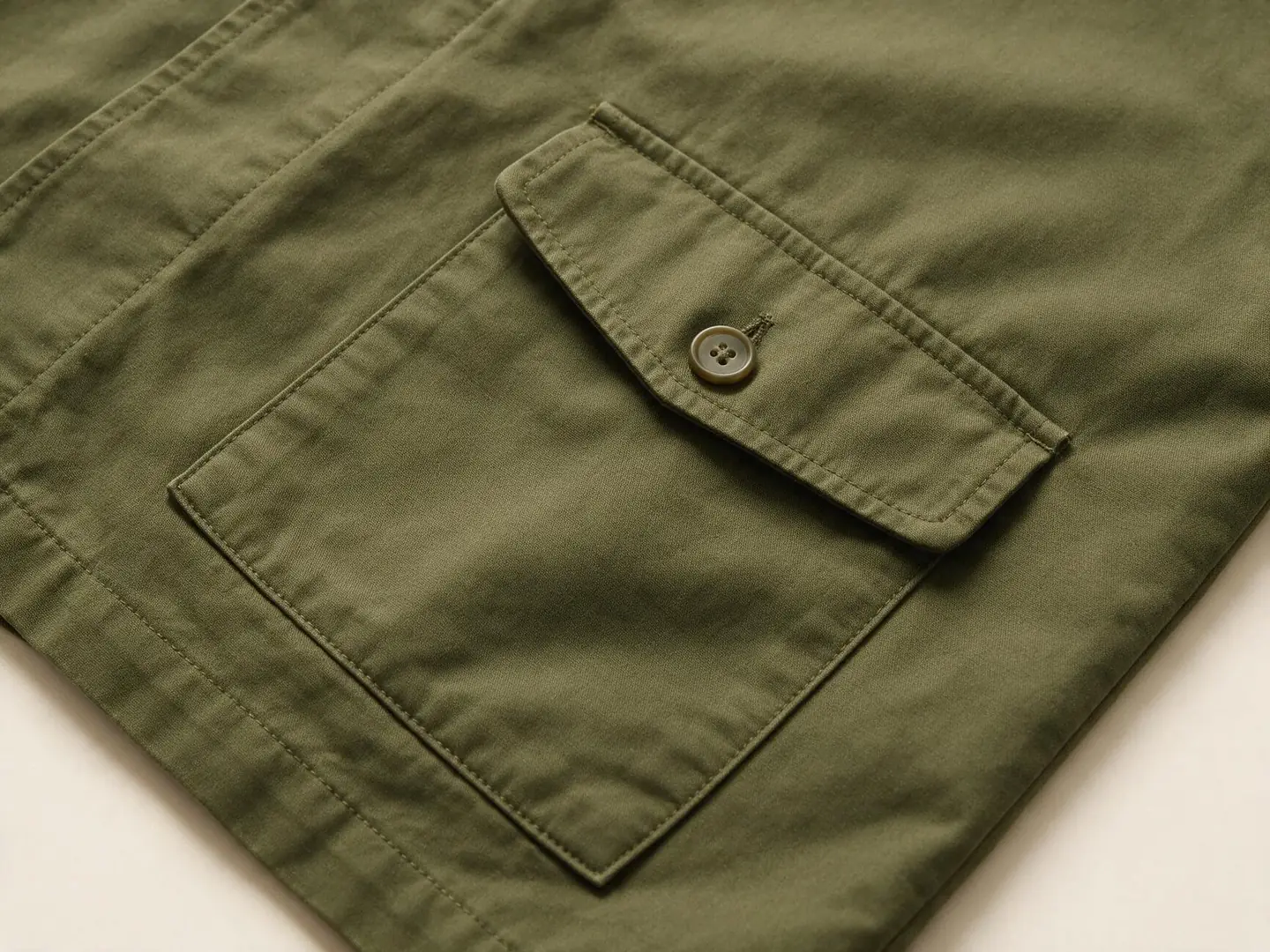 AI design concept showing an olive jacket patch pocket with a buttoned flap and visible stitching