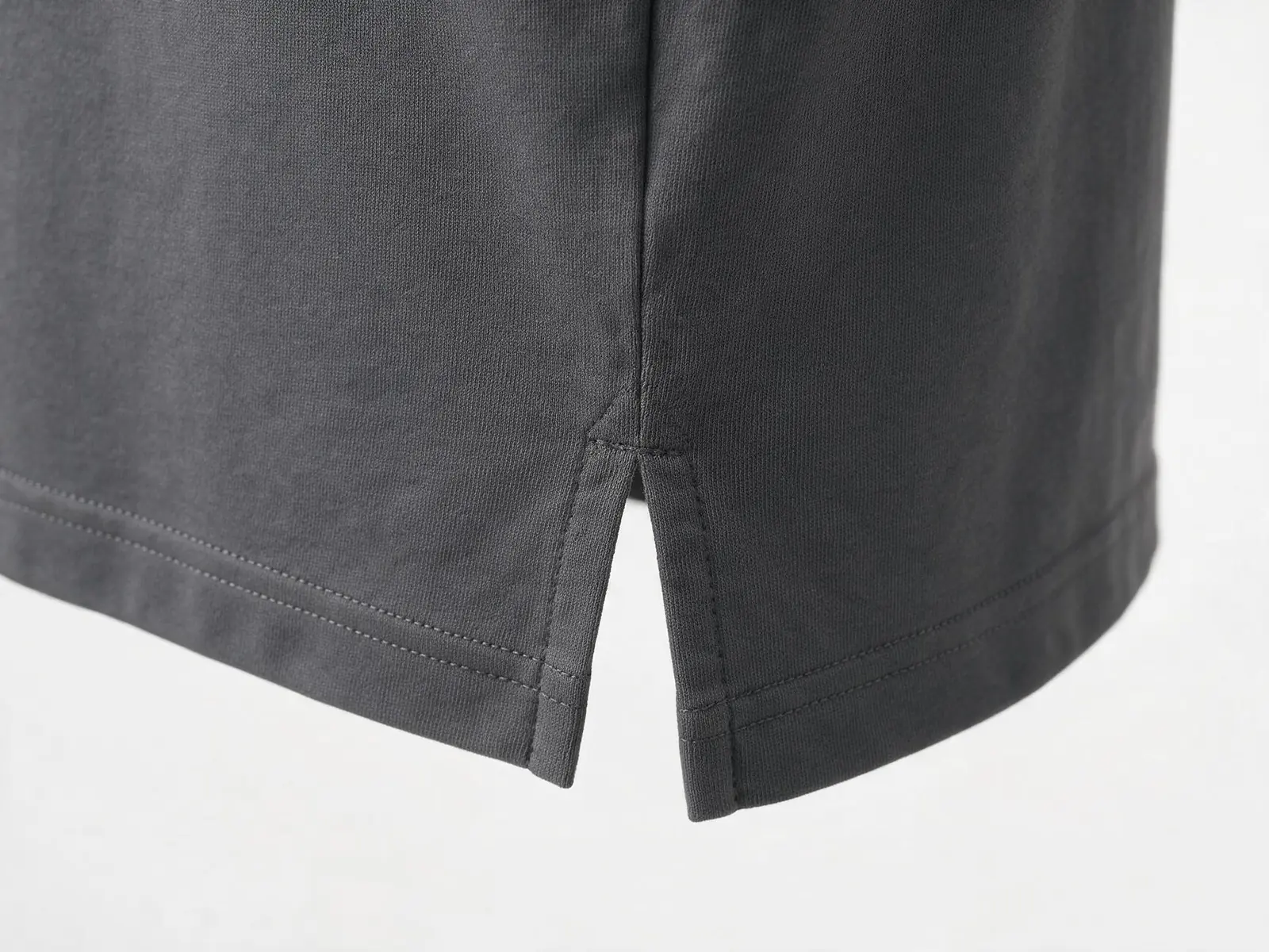 AI design concept showing a charcoal T-shirt side seam, short slit and stitched hem.