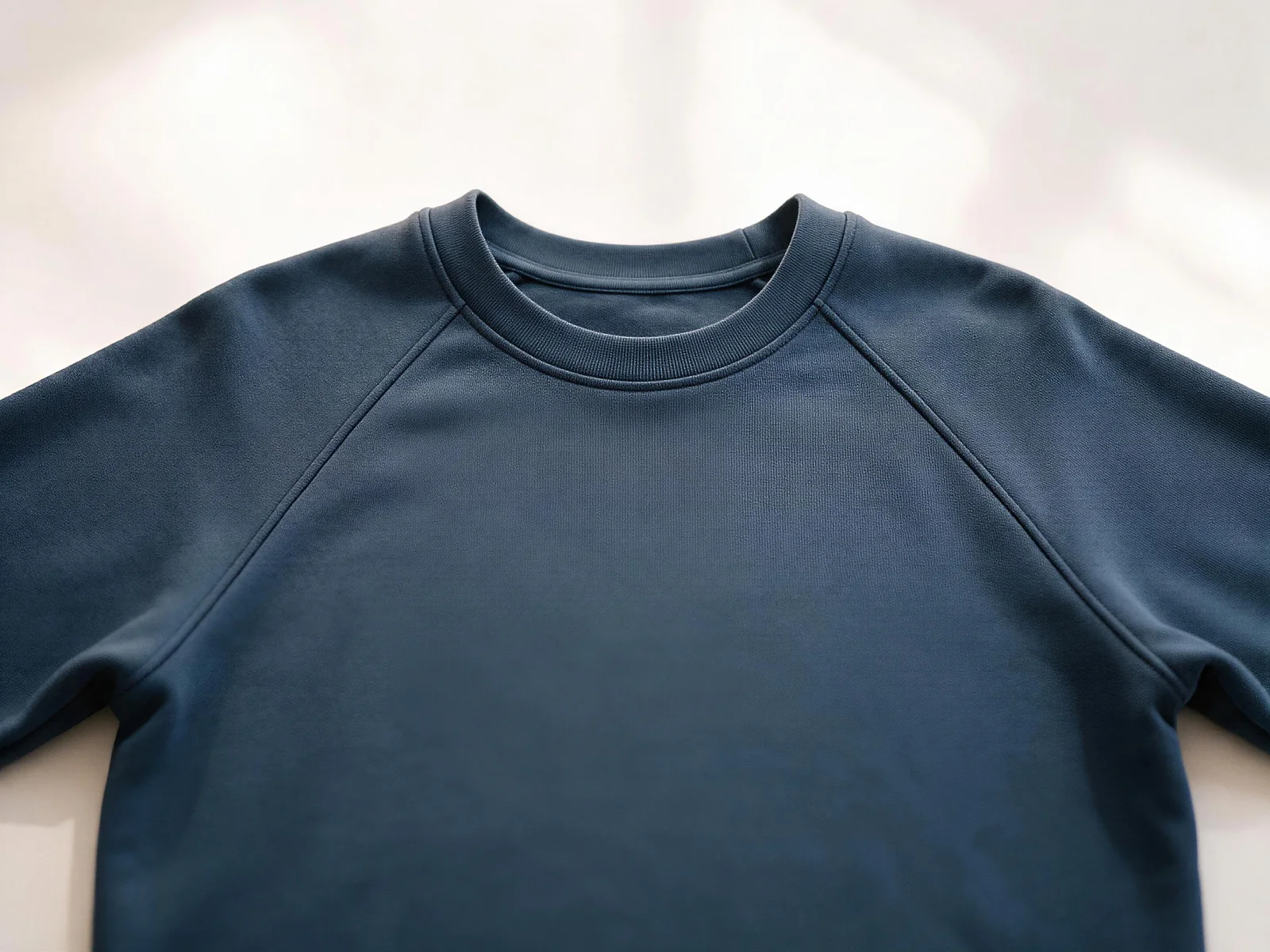 AI design concept showing raglan seams extending from the neckline across a navy crewneck sweatshirt