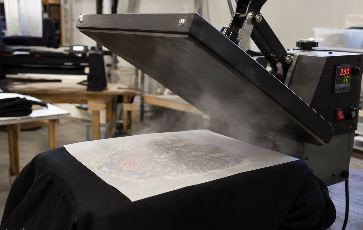 Heat press applying a transfer onto a garment